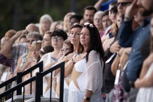 People standing with hand over heart during the 2026 GWOT Memorial Rededication